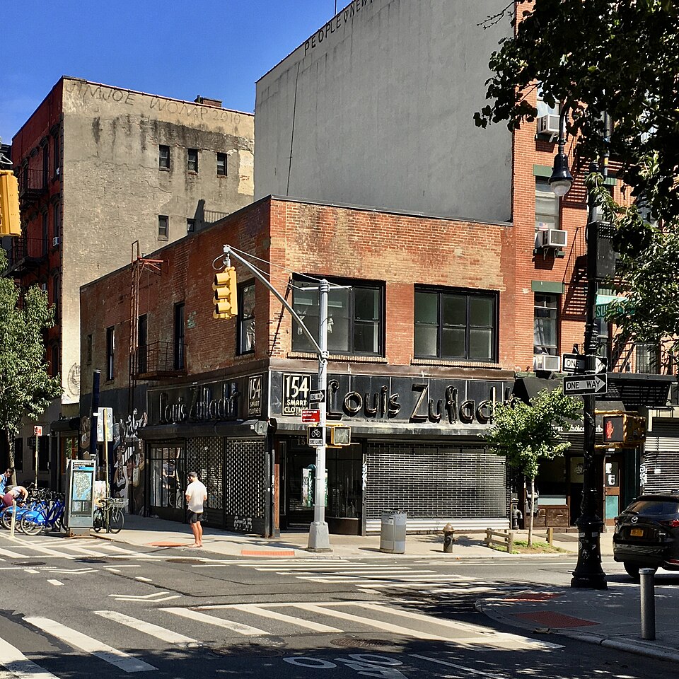 154 Stanton Street at a corner, with the Louis Zuflacht Smart Clothes sign across the storefront.