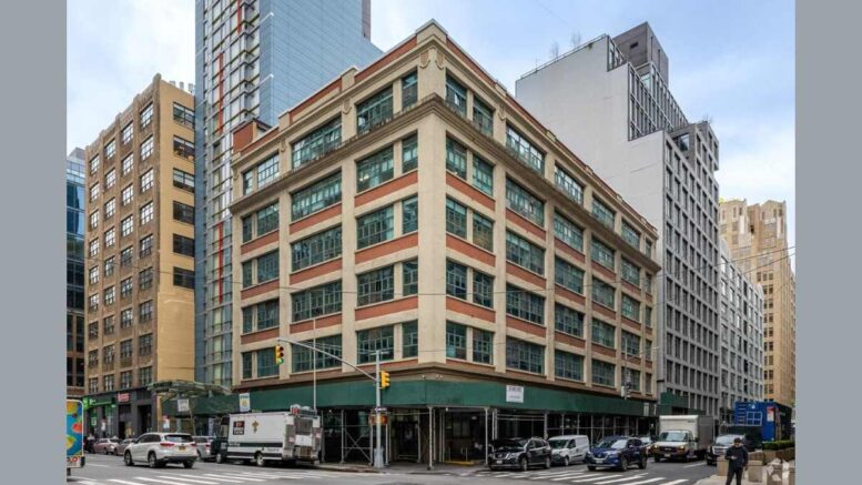 Corner view of the six-story commercial building at 68 King Street and 183 Varick Street with a sidewalk shed and traffic.