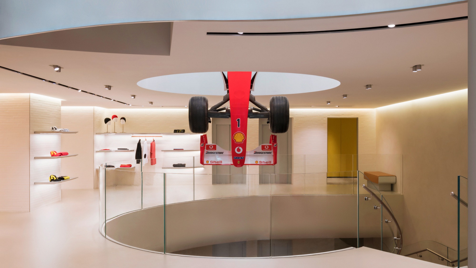 An existing Ferrari flagship store interior with a Formula 1 car hanging in the atrium.