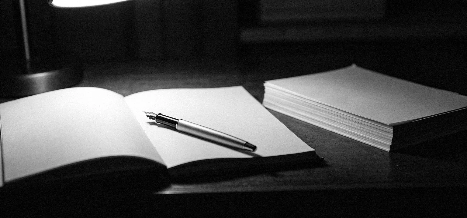 A blank notepad with a fountain pen, the quiet of working out a lease's true numbers by hand.