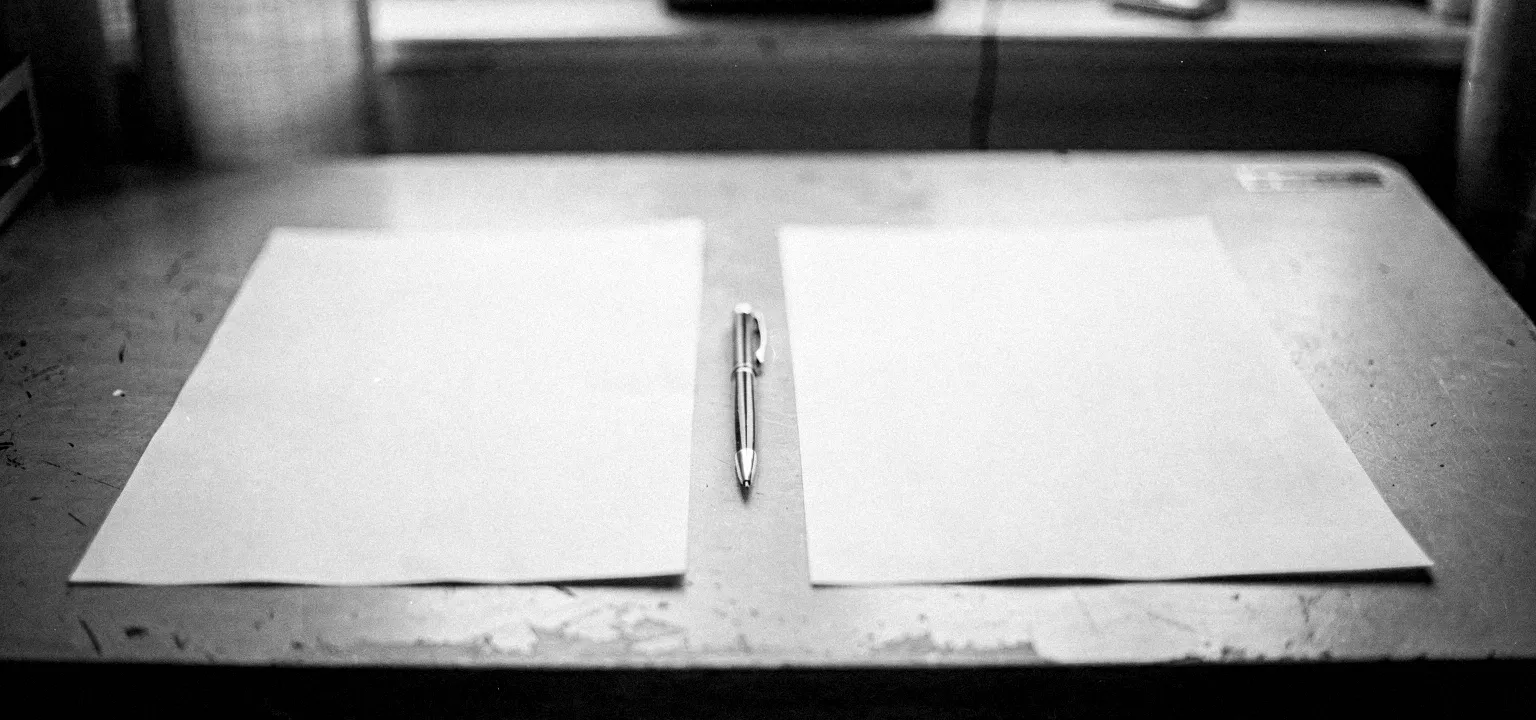 Two blank proposal forms laid side by side with a pen between them, comparing offers line by line.